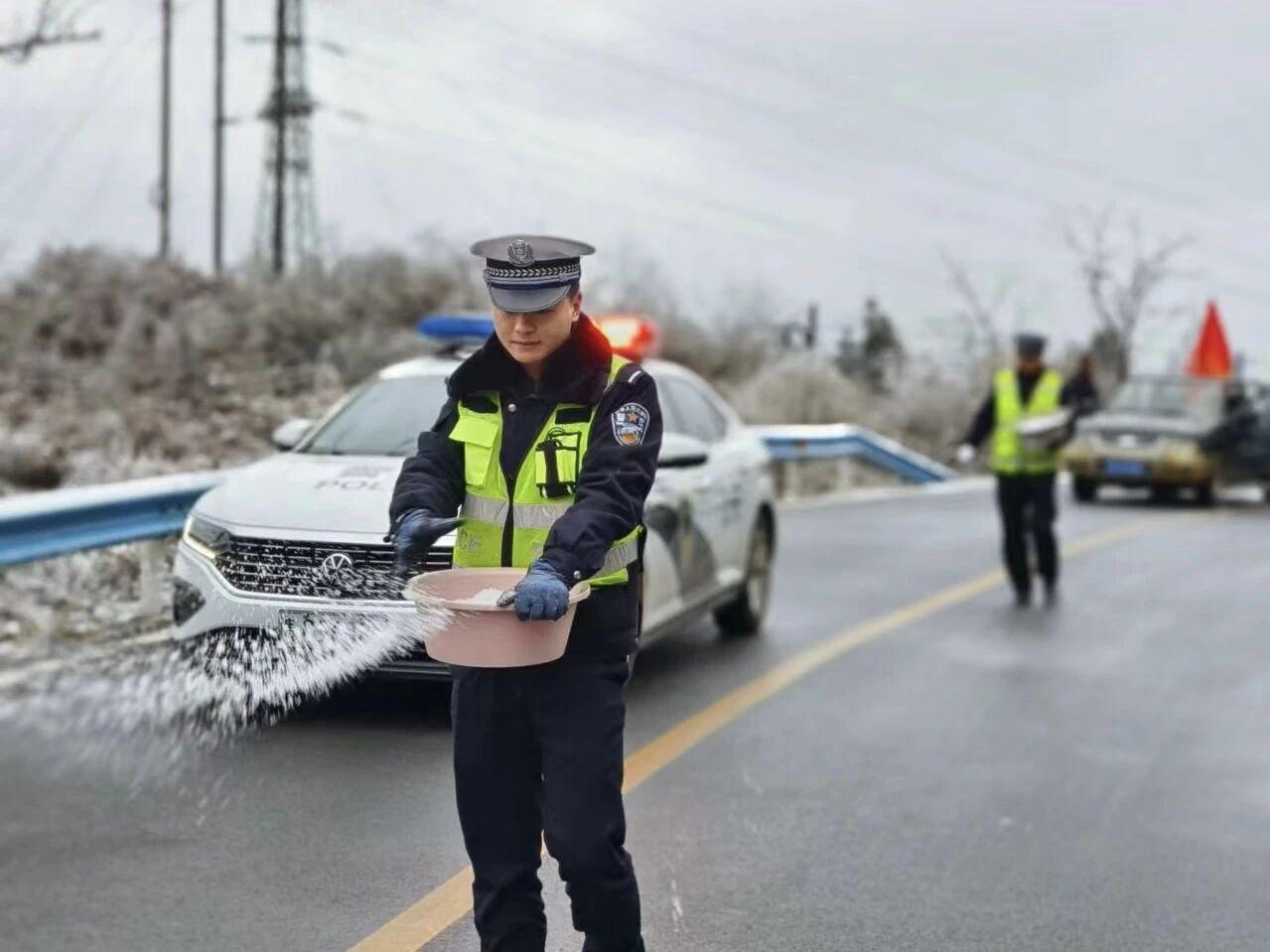 圖1民警在轄區(qū)結(jié)冰路段開展撒鹽除冰防凍工作。.jpg