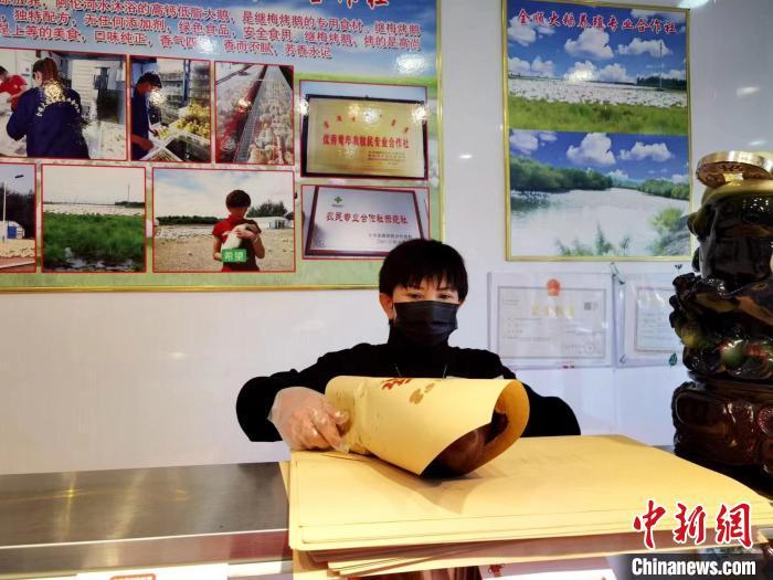 圖為鄭繼梅正在打包烤鵝?！≈x宏秀供圖