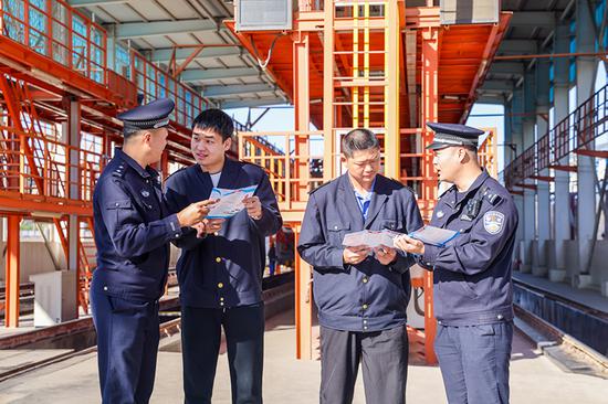 刑警支隊(duì)民警向企業(yè)職工發(fā)放宣傳資料并“一對一”講解電詐常識。謝仁古力·托呼提 攝